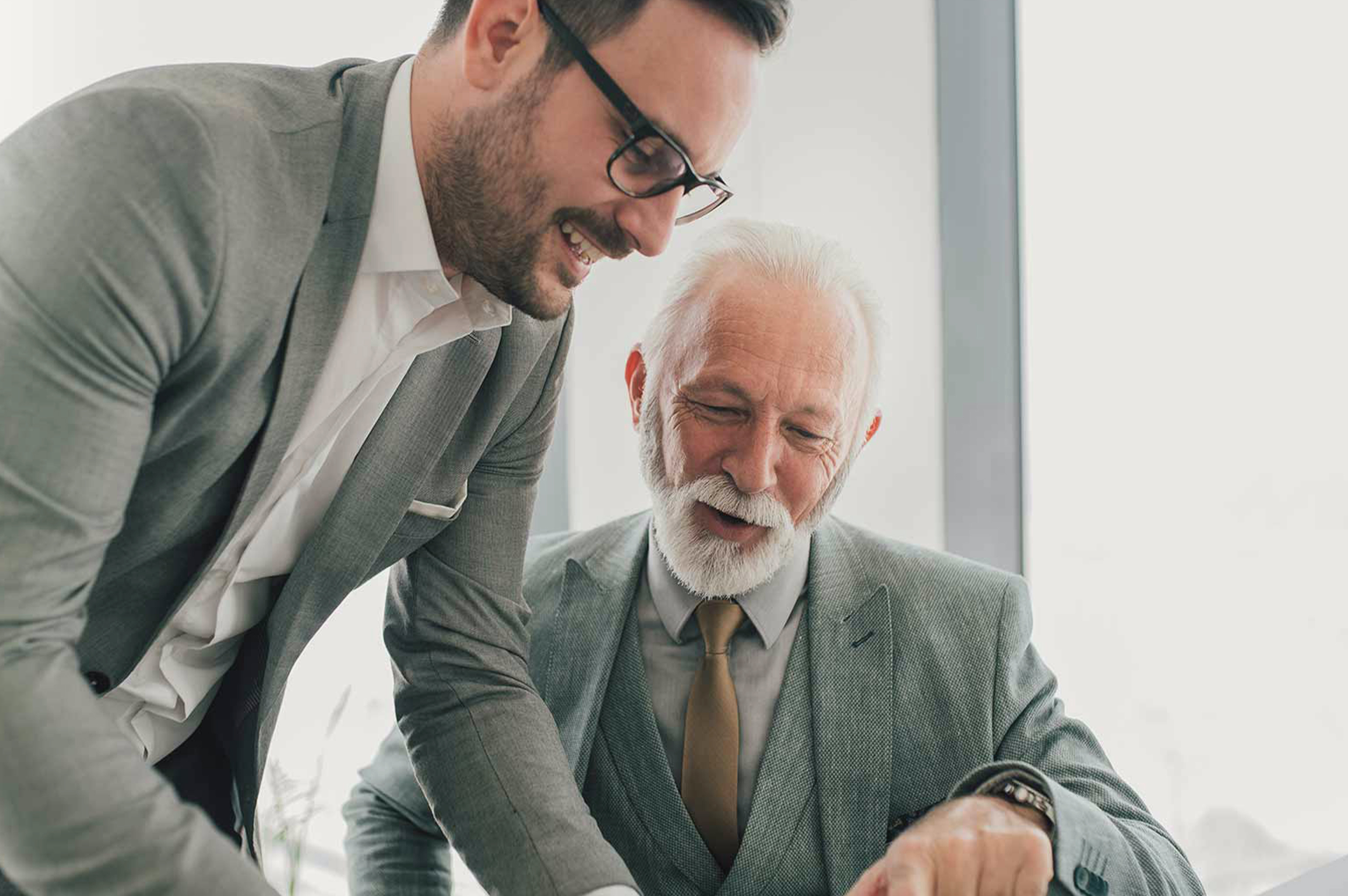 Zwei Männer in Business-Anzügen führen eine Beratungsdiskussion – exemplarisch für die persönliche, konservative Vermögensverwaltung von Azemos.