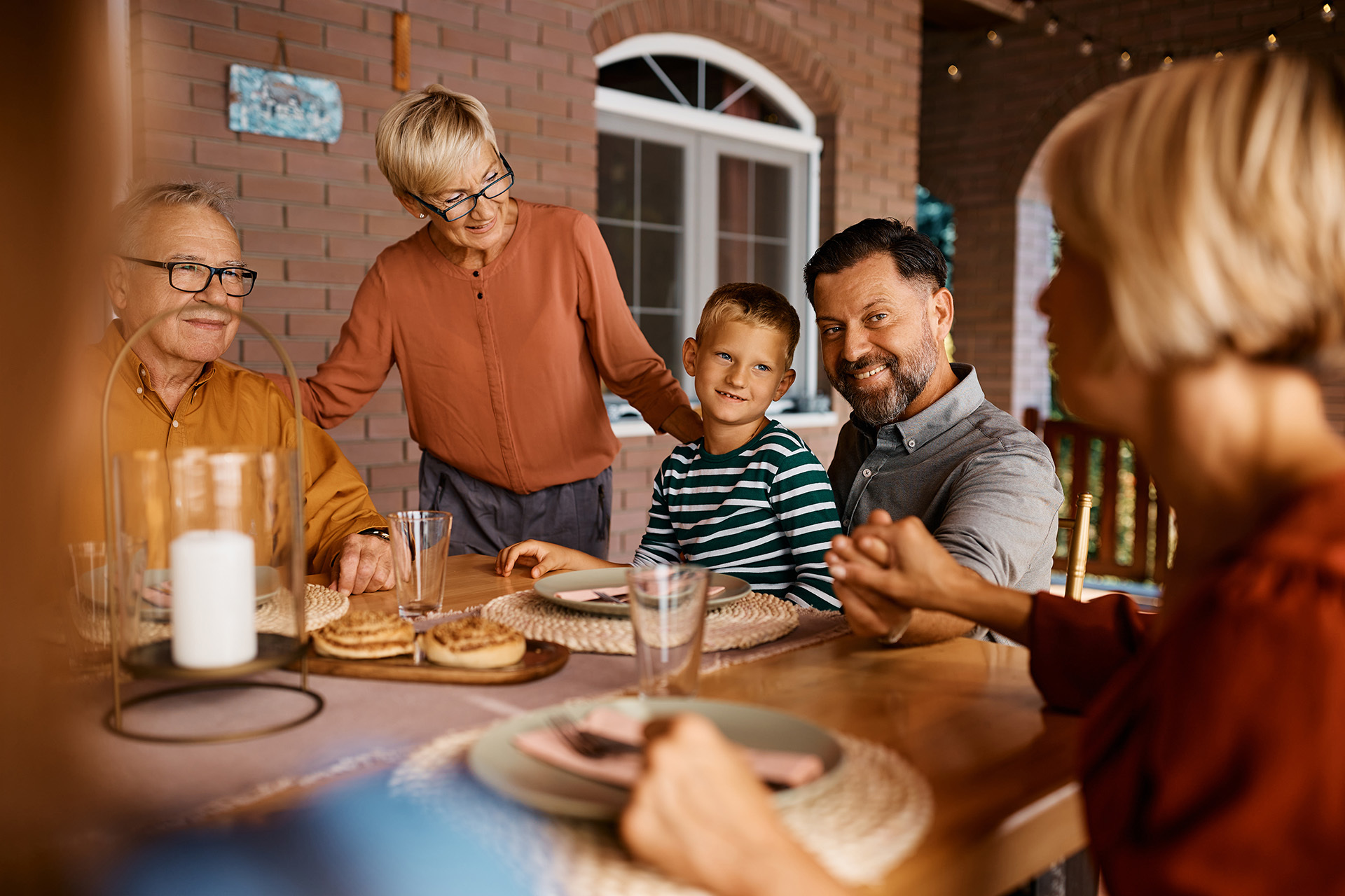 Eine Familie genießt eine gemeinsame Mahlzeit am Esstisch – ein Bild von Wärme, Vertrauen und langfristiger Verbundenheit, das die Werte von Azemos für verantwortungsvolle, persönliche Vermögensverwaltung widerspiegelt.